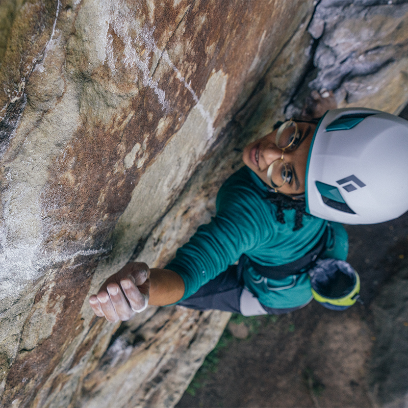 woman rock climbing with helmet and gear