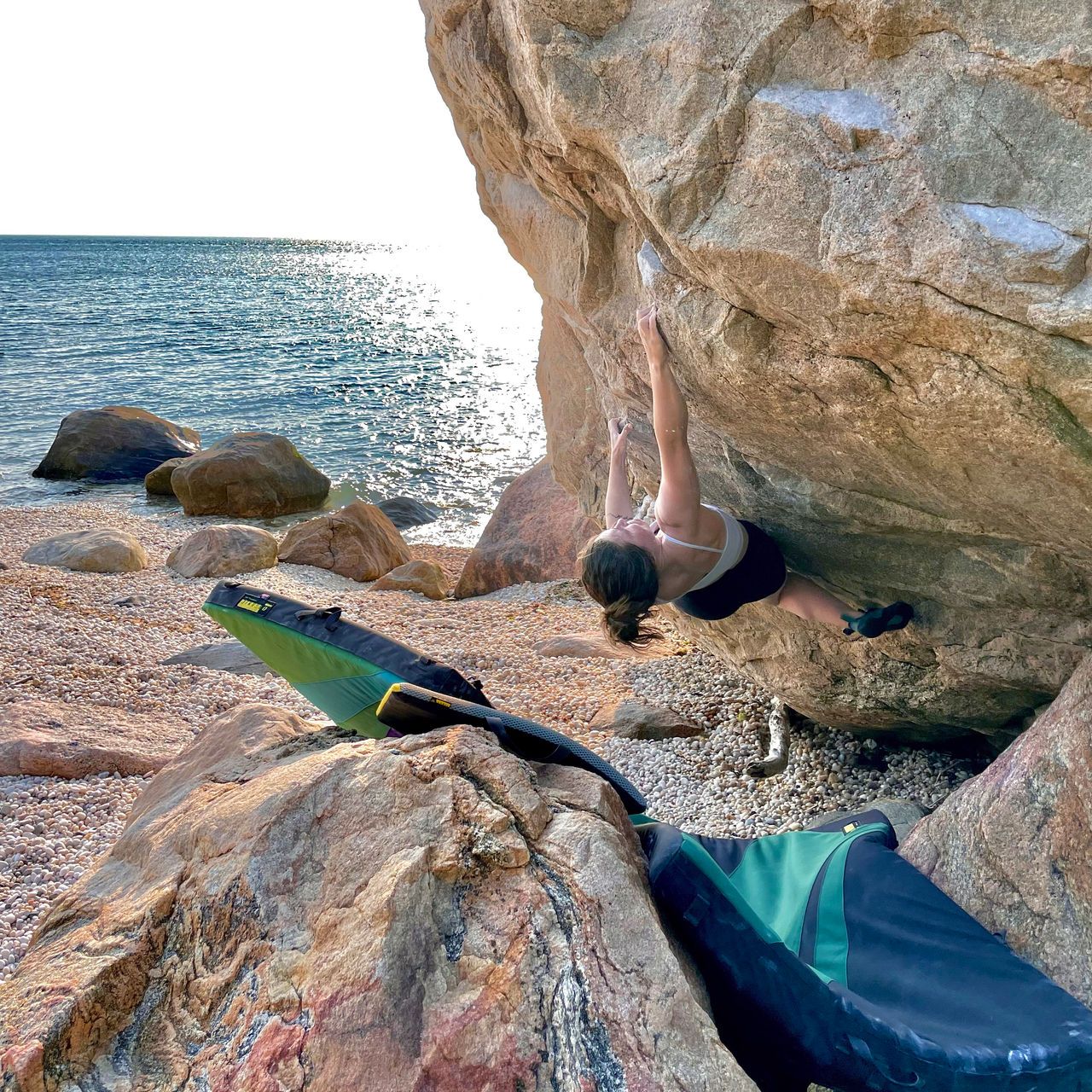 A woman works on a boulder problem at East Marion