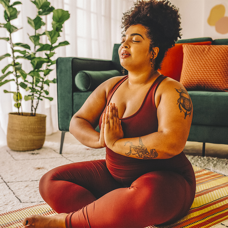 A woman practicing relaxation yoga at home