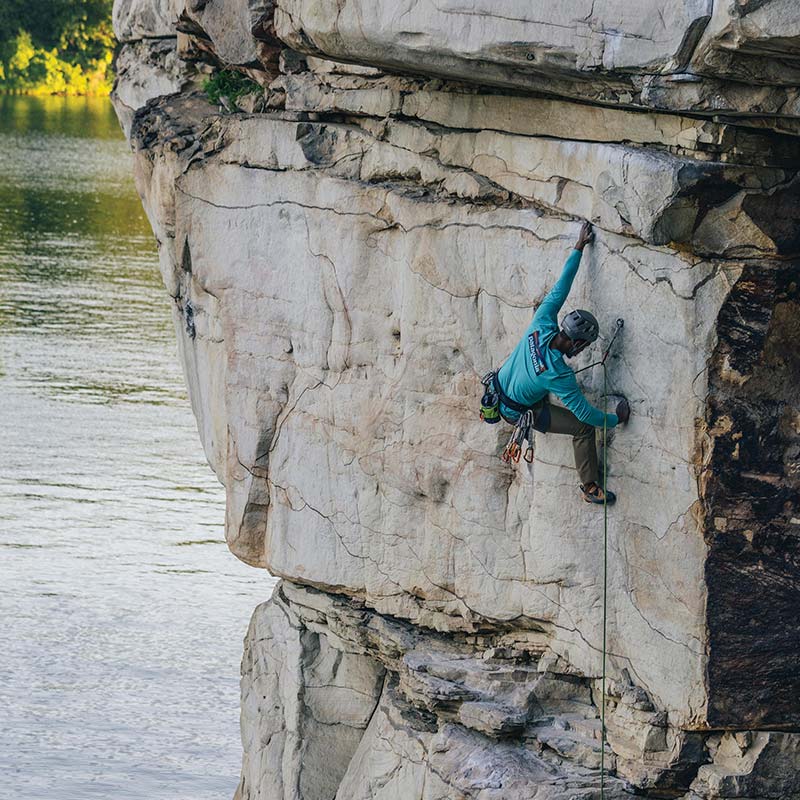 Climber on a rock face wearing long sleeves
