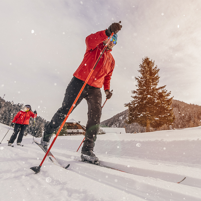 Man cross-country skiing during sunny winter day.