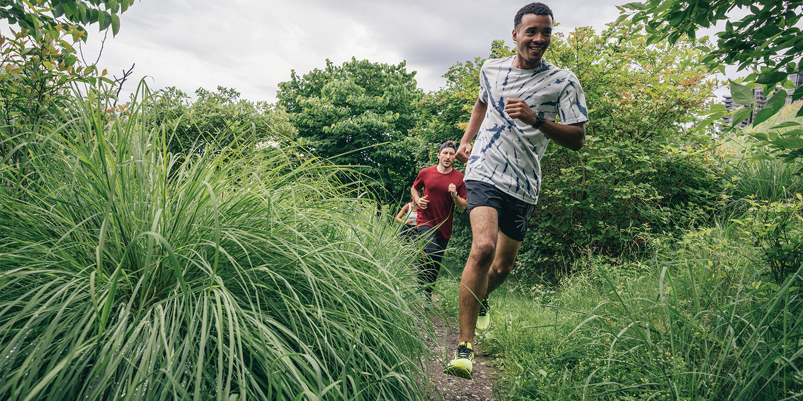 Three runners running on a trail 